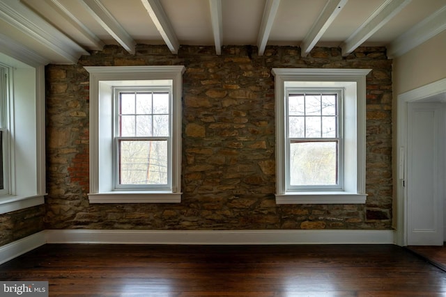 interior space with beam ceiling, plenty of natural light, and dark wood-type flooring