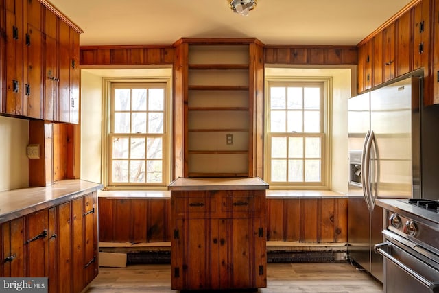 kitchen with appliances with stainless steel finishes, light wood-type flooring, and a healthy amount of sunlight