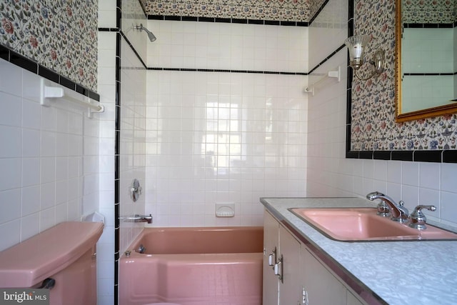 full bathroom with vanity, tiled shower / bath, toilet, tile walls, and tasteful backsplash