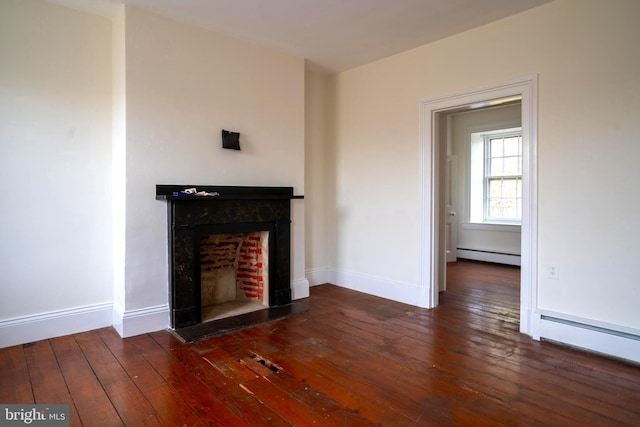 unfurnished living room with dark hardwood / wood-style flooring and a baseboard heating unit