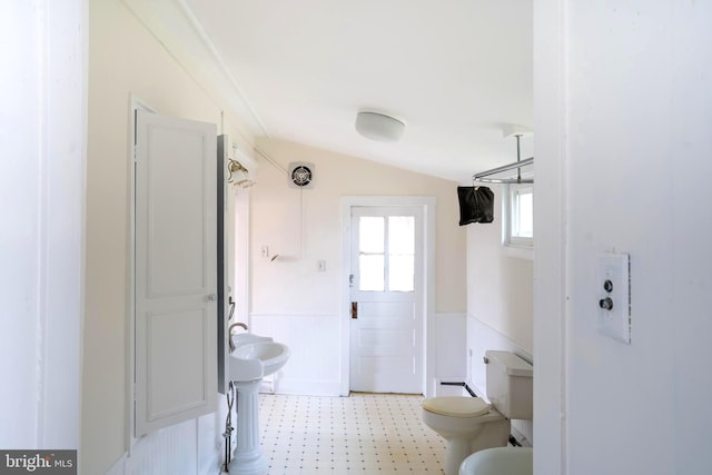 bathroom with vaulted ceiling, toilet, and ornamental molding