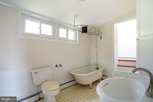 bathroom featuring a tub to relax in, toilet, a baseboard heating unit, and sink