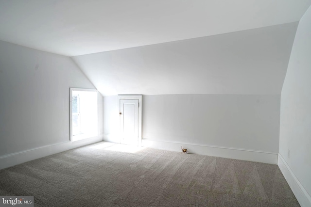 bonus room with carpet floors and vaulted ceiling