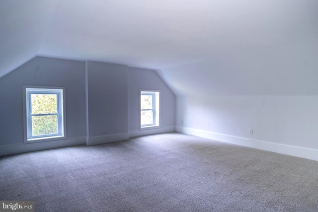 bonus room with carpet flooring, a wealth of natural light, and lofted ceiling