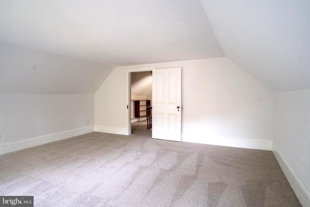 additional living space with carpet floors and vaulted ceiling