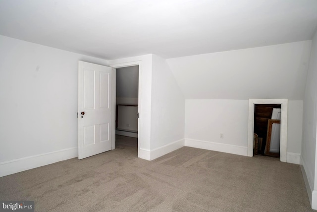 bonus room with light colored carpet, vaulted ceiling, and a baseboard heating unit