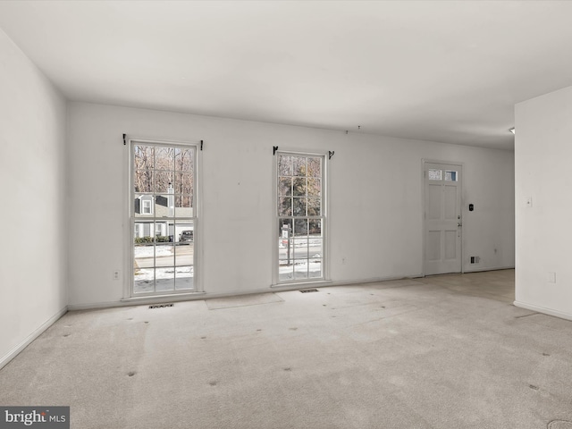 carpeted spare room featuring a healthy amount of sunlight