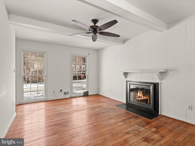 unfurnished living room with ceiling fan, light hardwood / wood-style flooring, and beamed ceiling