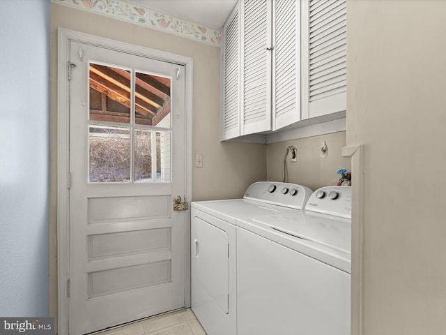 clothes washing area featuring light tile patterned flooring, cabinets, and washer and clothes dryer