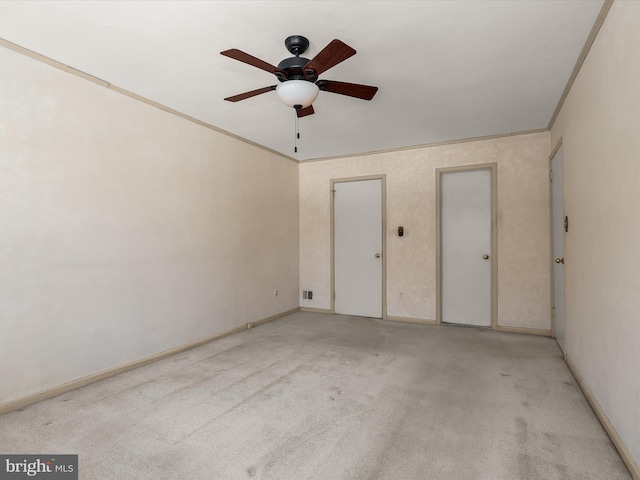 carpeted empty room featuring ornamental molding and ceiling fan