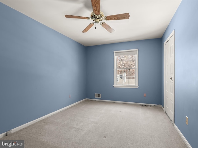 carpeted spare room featuring ceiling fan