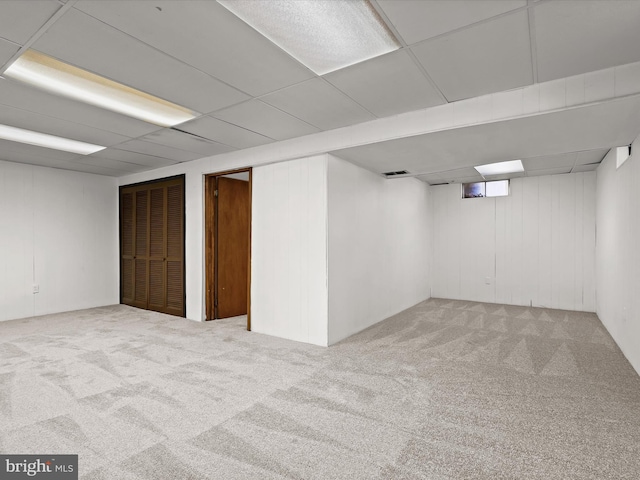 basement featuring carpet flooring and a drop ceiling