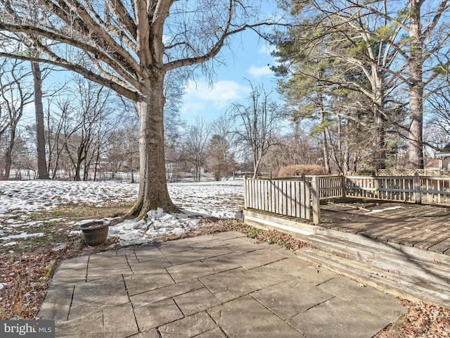 snow covered patio featuring a wooden deck