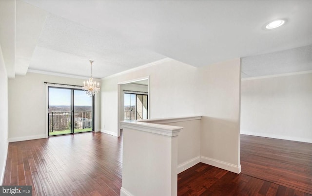 unfurnished room with a chandelier, ornamental molding, and dark hardwood / wood-style floors