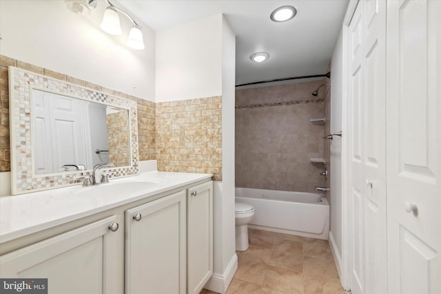 full bathroom with toilet, tiled shower / bath, tile patterned floors, and vanity