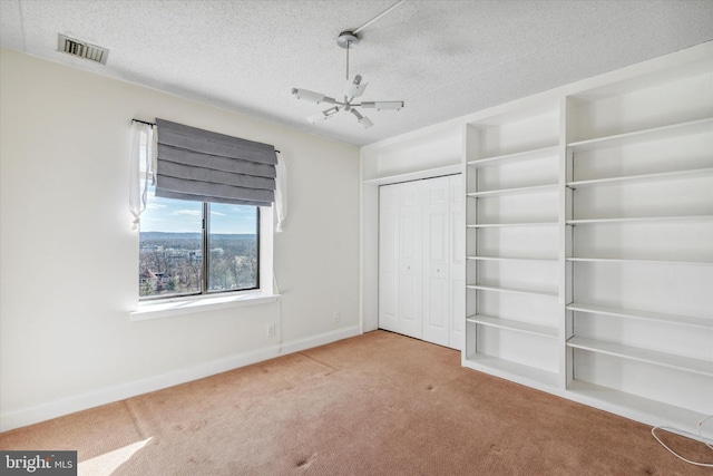 unfurnished bedroom with a closet, a textured ceiling, ceiling fan, and carpet