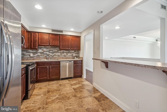 kitchen with kitchen peninsula, stainless steel appliances, backsplash, and sink