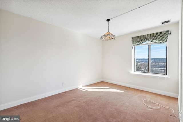 spare room with a textured ceiling and light carpet