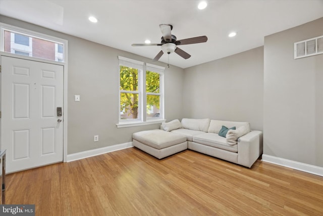 living room featuring ceiling fan and light hardwood / wood-style flooring