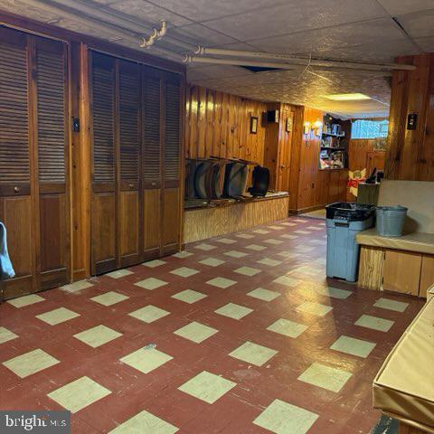 finished below grade area featuring wood walls and tile patterned floors