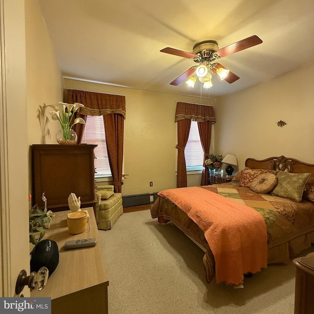 carpeted bedroom with a baseboard radiator and a ceiling fan