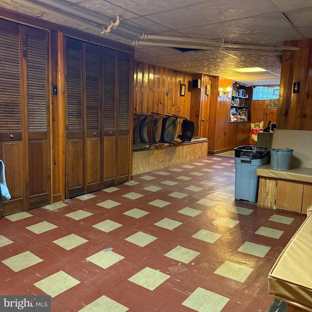 finished below grade area featuring wood walls and tile patterned floors