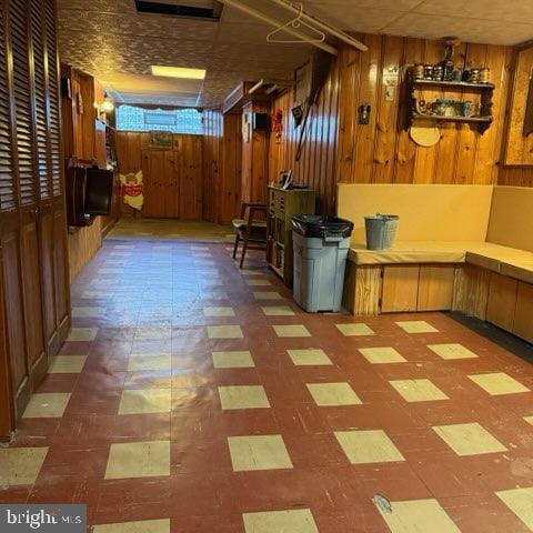 basement with wood walls and tile patterned floors