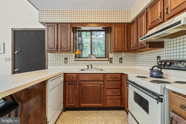 kitchen with kitchen peninsula, decorative backsplash, sink, and white appliances