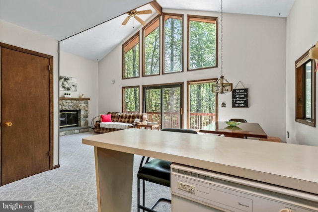 kitchen featuring light carpet, high vaulted ceiling, plenty of natural light, and a fireplace