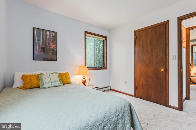 bedroom with light colored carpet and a baseboard heating unit