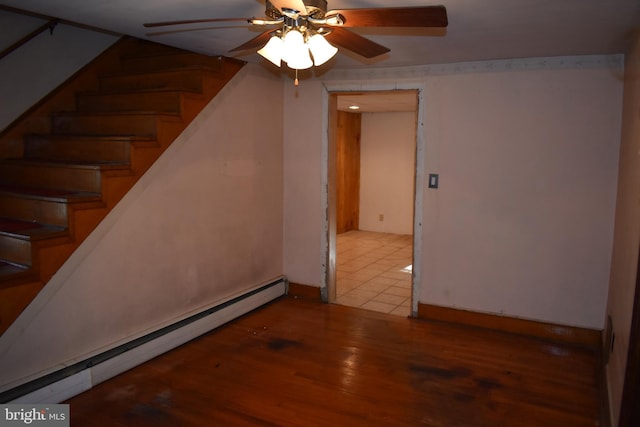 interior space featuring ceiling fan, stairway, baseboard heating, and wood finished floors