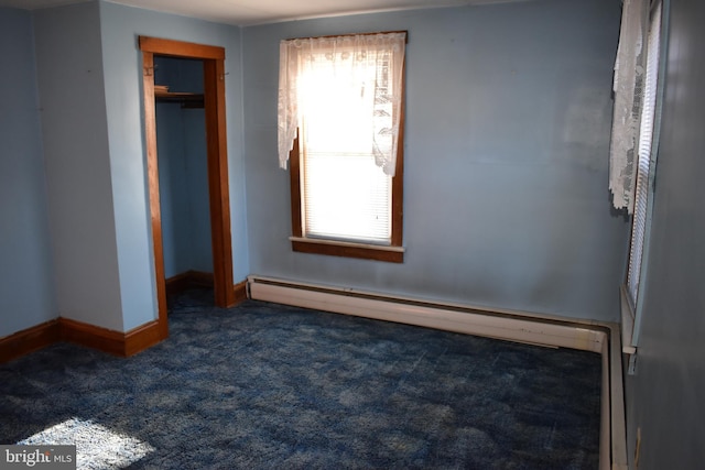 unfurnished bedroom featuring dark colored carpet, a closet, and baseboards