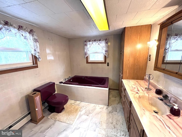 bathroom featuring toilet, vanity, marble finish floor, baseboard heating, and a bath