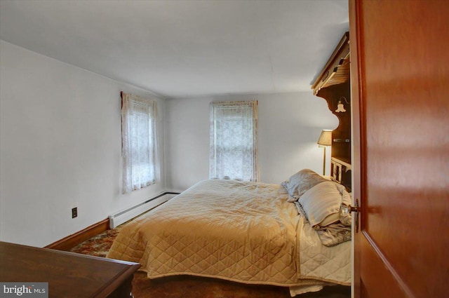 bedroom with a baseboard heating unit and baseboards