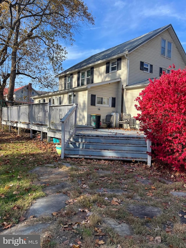 rear view of property featuring a wooden deck