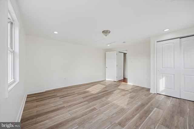 unfurnished bedroom featuring light wood-type flooring and a closet