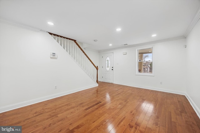 unfurnished living room with hardwood / wood-style floors and ornamental molding