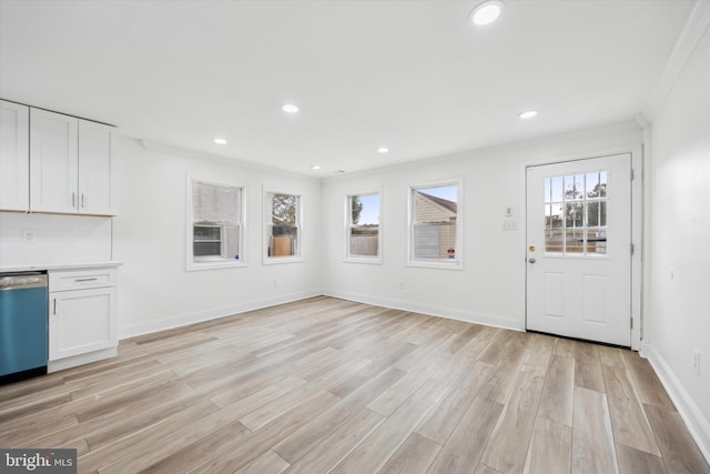 unfurnished living room featuring light hardwood / wood-style floors and crown molding