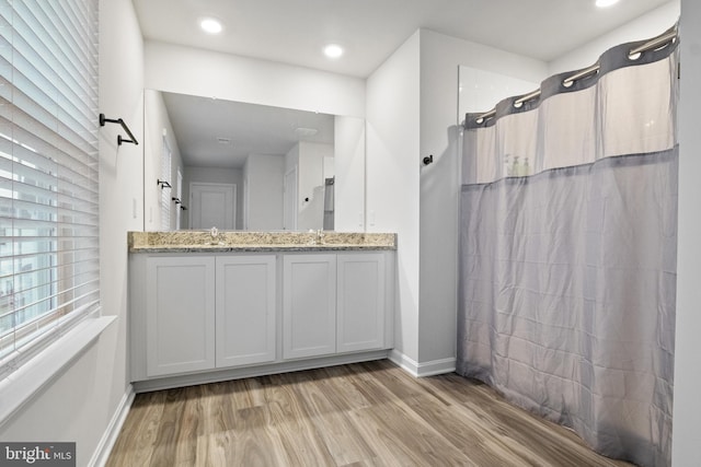 bathroom with vanity, wood-type flooring, and walk in shower