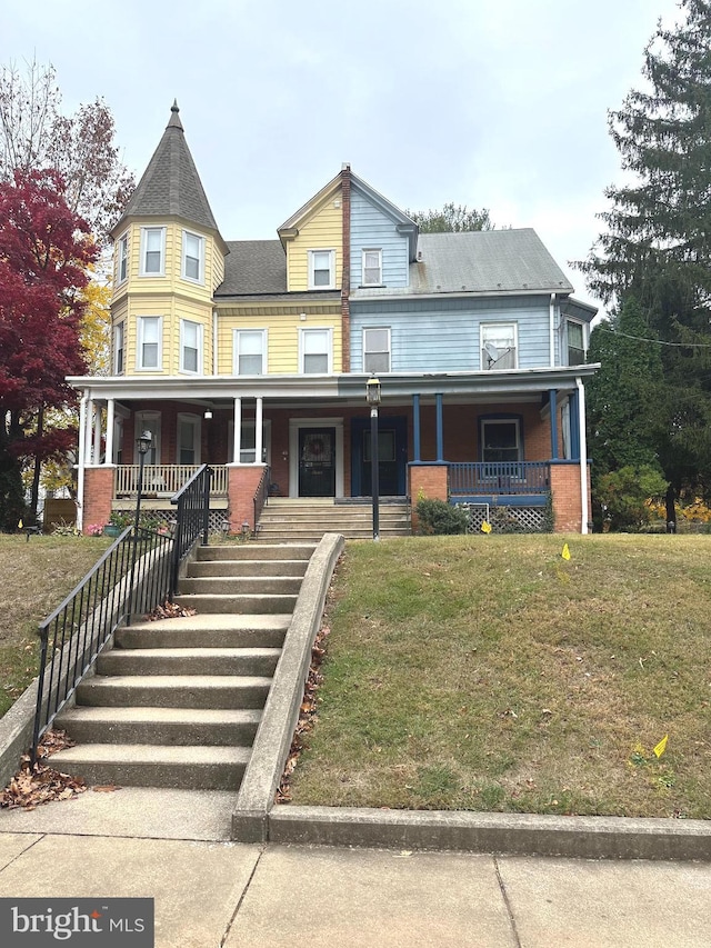 victorian house with a front lawn and a porch