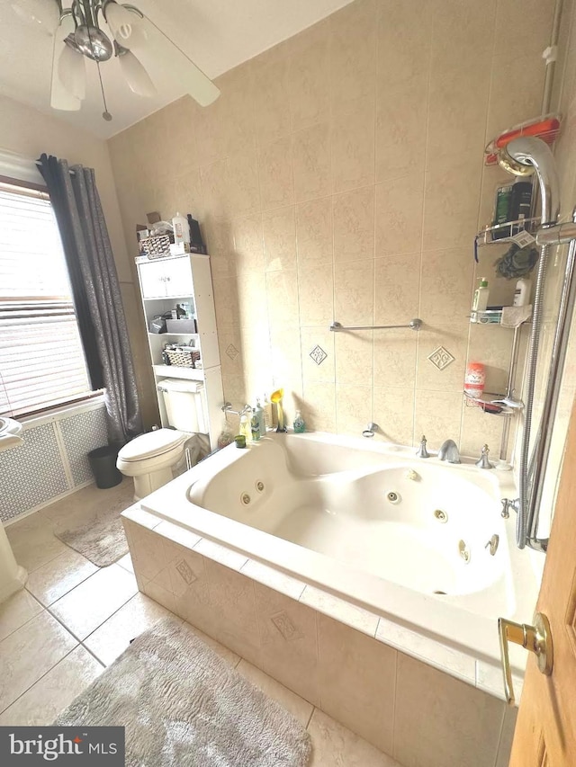 bathroom with tile patterned flooring, toilet, tile walls, and tiled bath