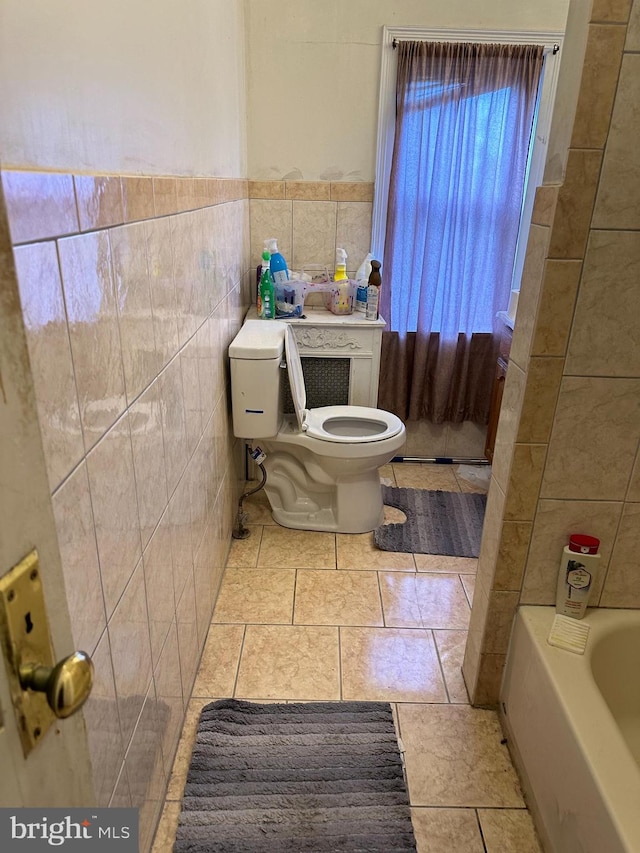 bathroom featuring a tub to relax in, tile walls, and toilet