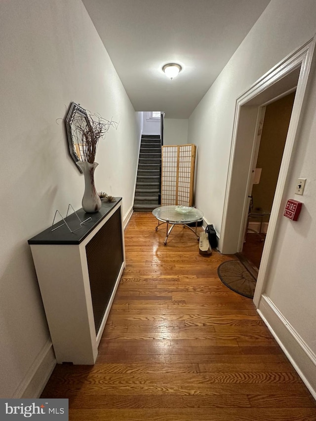 corridor with hardwood / wood-style flooring