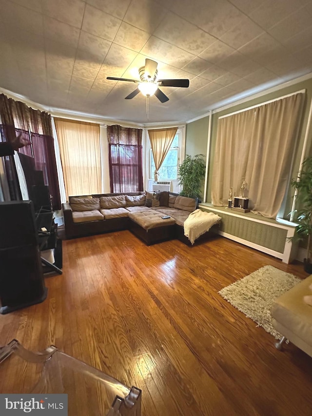 unfurnished living room with hardwood / wood-style floors, ceiling fan, and radiator