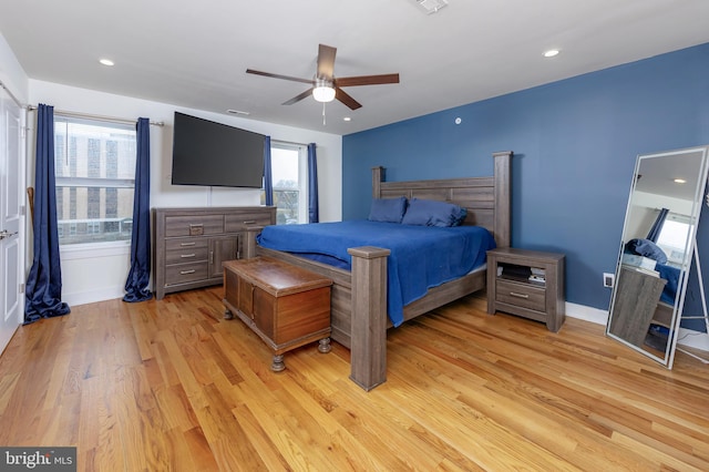 bedroom with multiple windows, ceiling fan, and light wood-type flooring