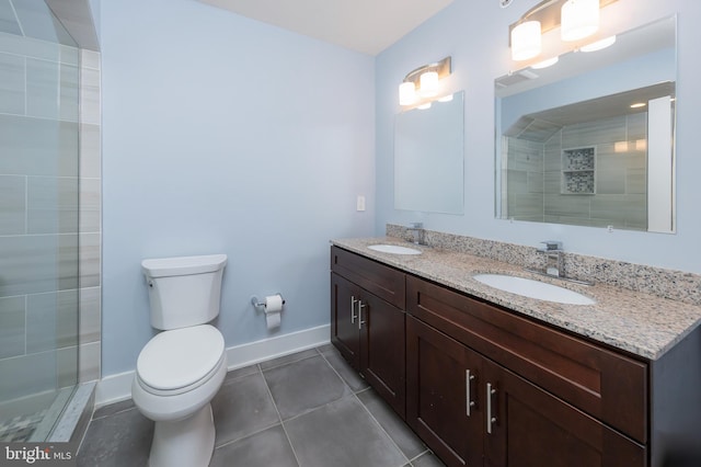 bathroom featuring tile patterned floors, vanity, tiled shower, and toilet