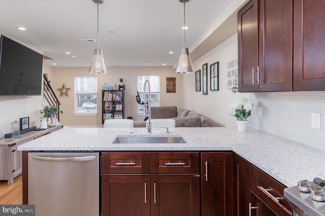 kitchen with dishwasher, light hardwood / wood-style floors, light stone countertops, and sink