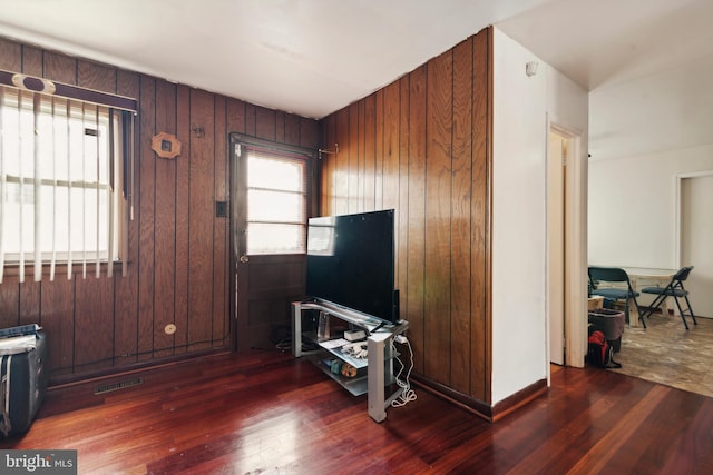 living room with dark hardwood / wood-style floors and wooden walls