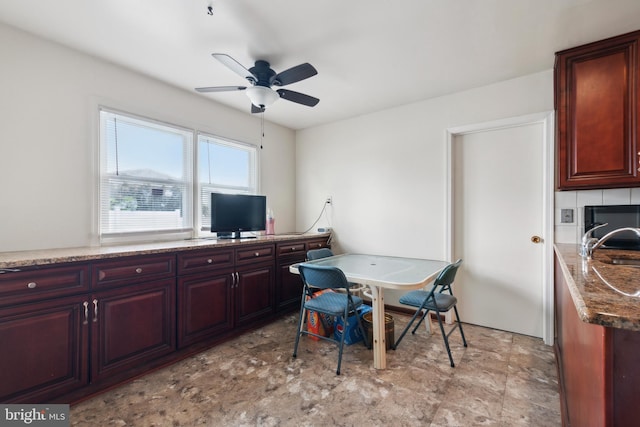 kitchen with stone countertops, ceiling fan, and sink