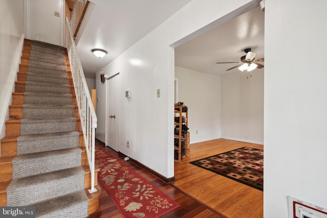 stairway with hardwood / wood-style flooring and ceiling fan